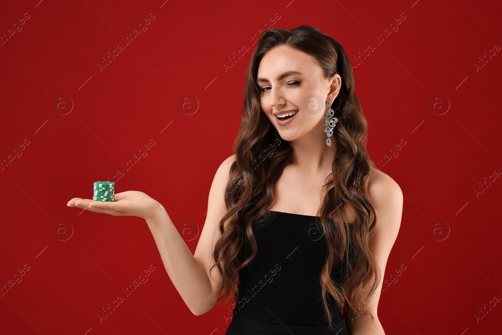 Photo of Smiling woman with poker chips on red background