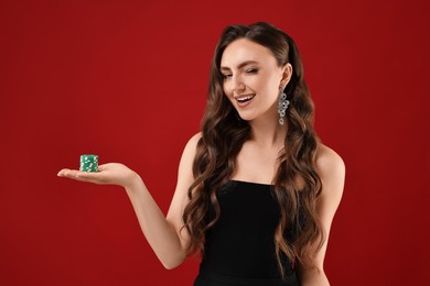 Photo of Smiling woman with poker chips on red background