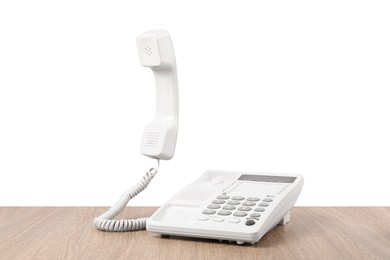 Telephone on wooden table against light background