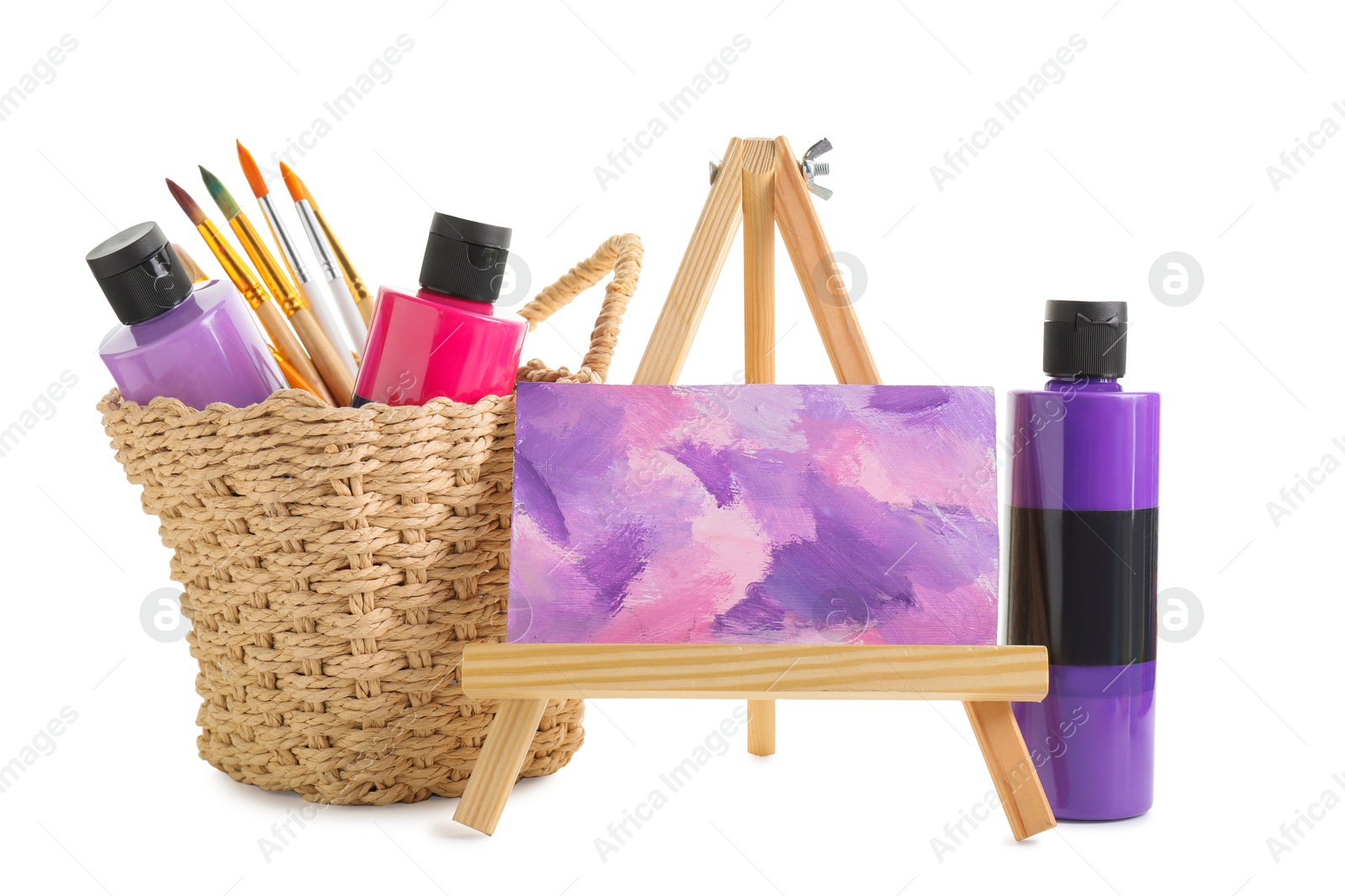 Photo of Acrylic paints of different colors with brushes and abstract picture on small easel against white background