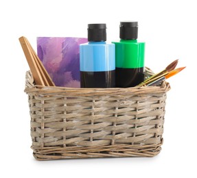 Acrylic paints of different colors with brushes and abstract picture in wicker basket isolated on white