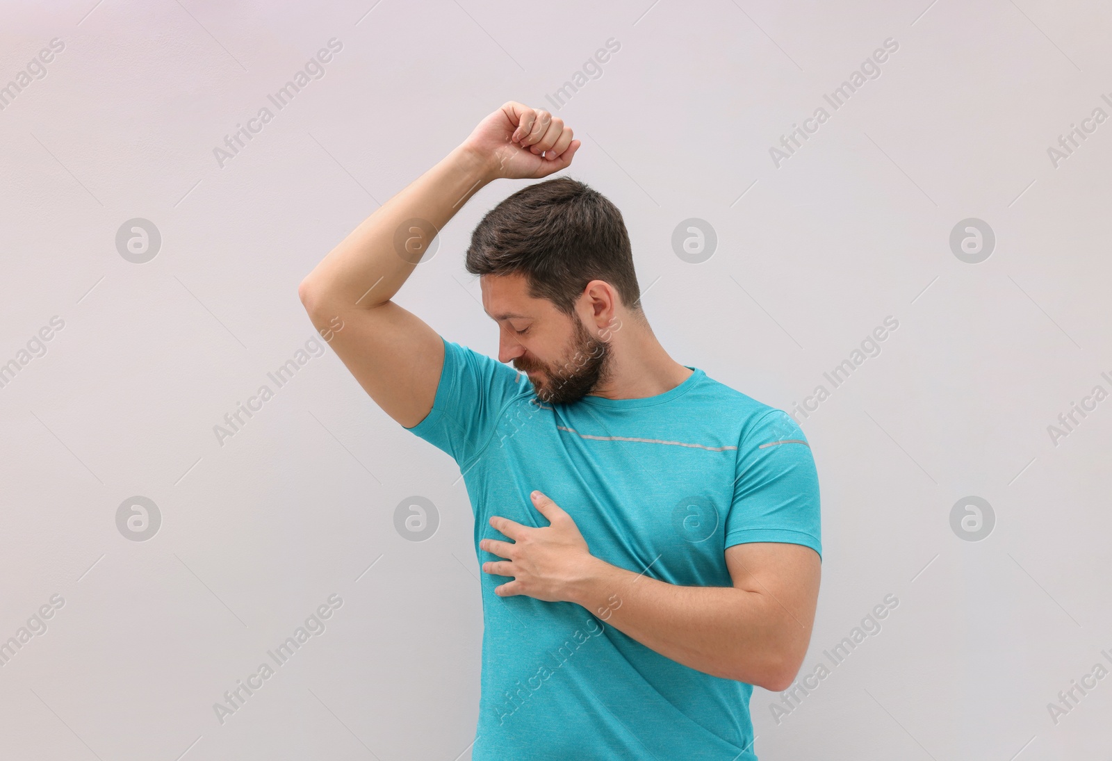 Photo of Handsome man after using deodorant on white background