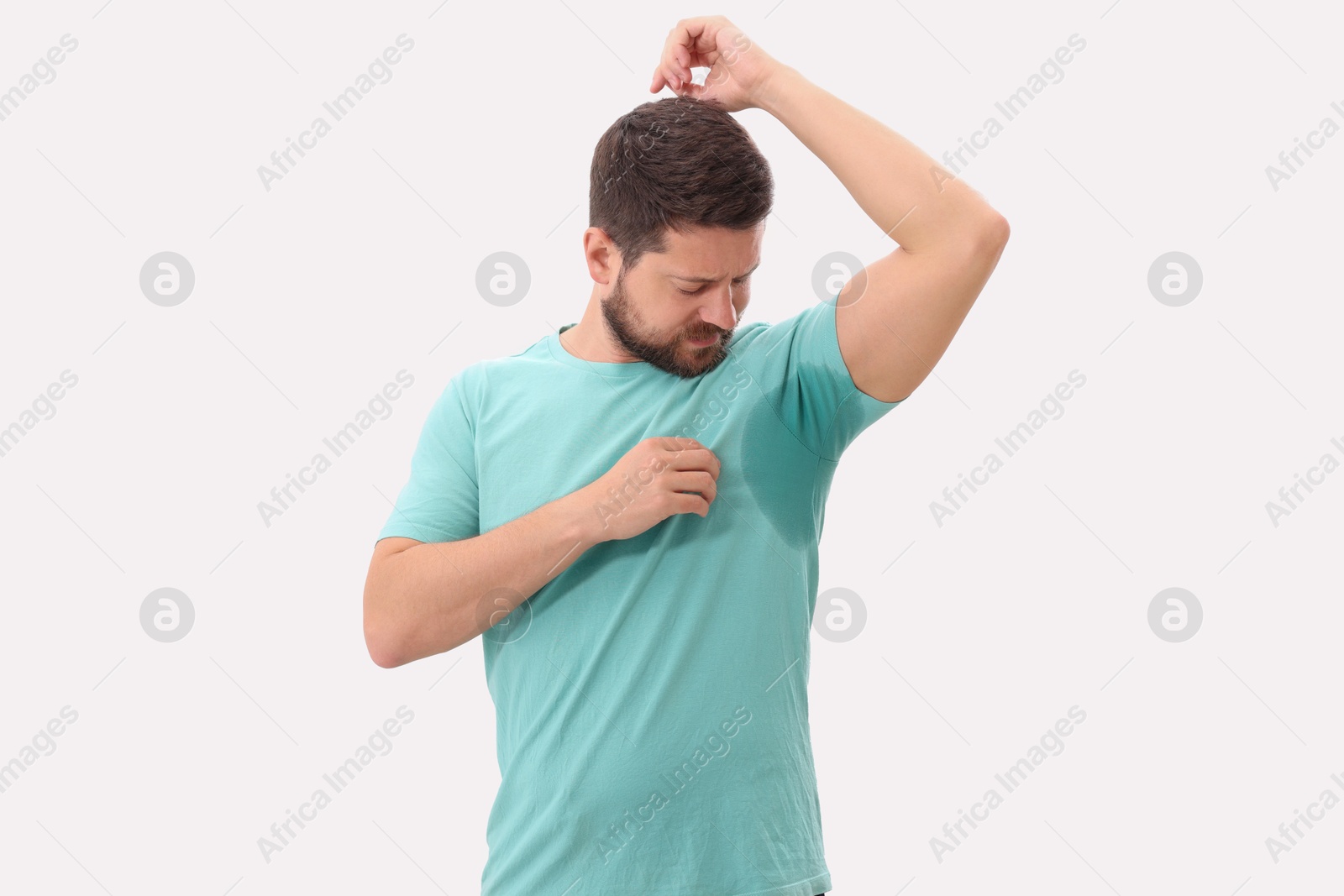 Photo of Emotional man in t-shirt before using deodorant on white background