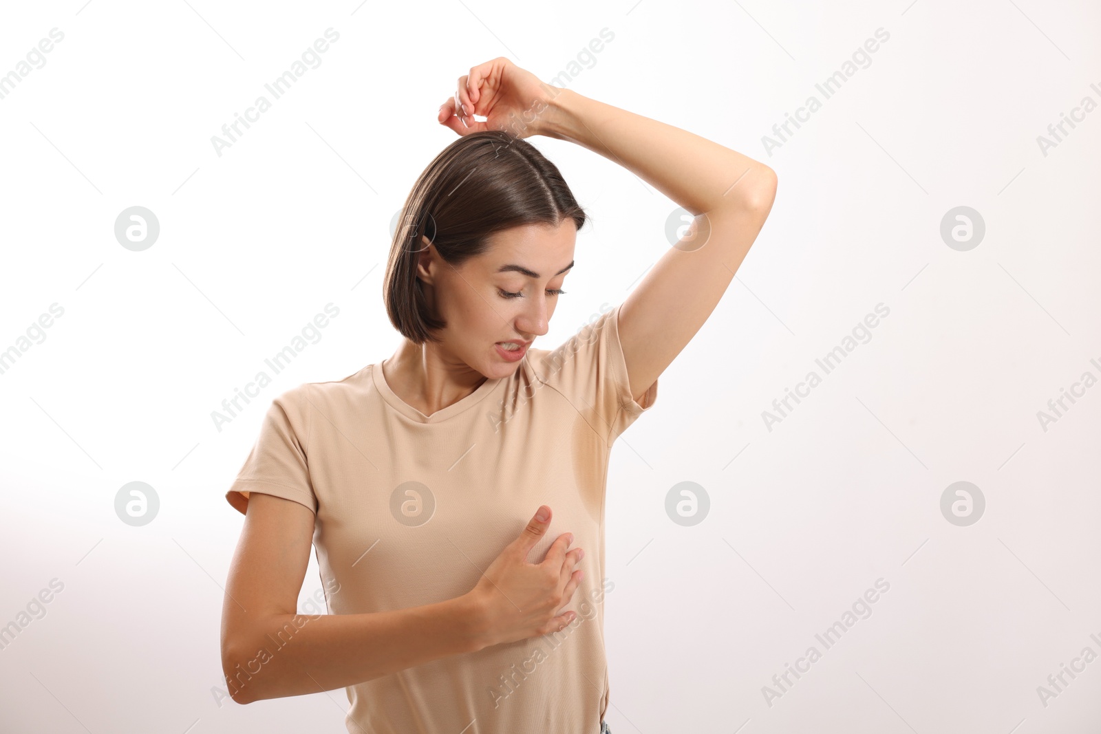 Photo of Emotional woman in t-shirt before using deodorant on white background