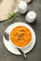 Photo of Delicious mashed sweet potatoes served on gray textured table, flat lay