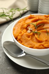 Photo of Delicious mashed sweet potatoes served on gray textured table, closeup