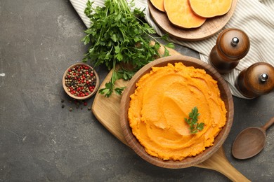 Delicious mashed sweet potatoes served on gray textured table, flat lay