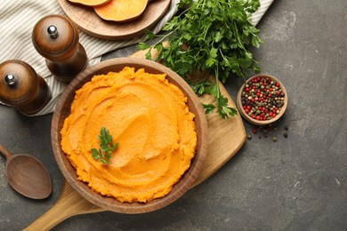 Photo of Delicious mashed sweet potatoes served on gray textured table, flat lay