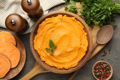 Photo of Delicious mashed sweet potatoes served on gray textured table, flat lay