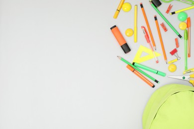 Photo of Backpack and different school supplies on light gray background, flat lay. Space for text