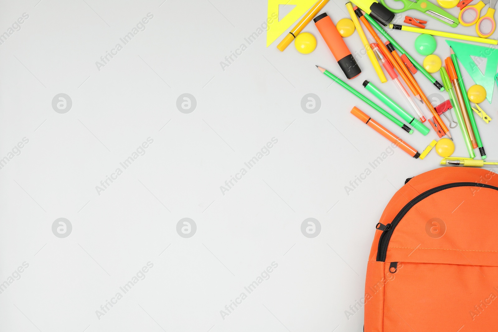 Photo of Backpack and different school supplies on light gray background, flat lay. Space for text