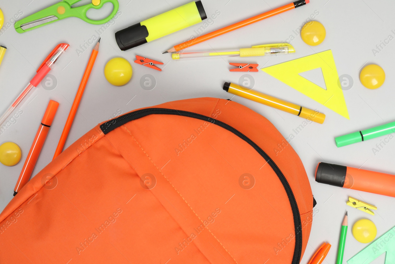 Photo of Backpack and different school supplies on light gray background, flat lay