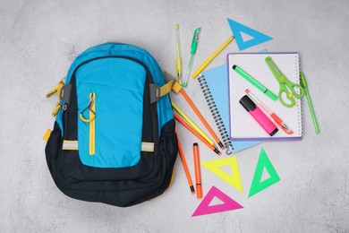 Photo of Flat lay composition with backpack and different school stationery on light grey table