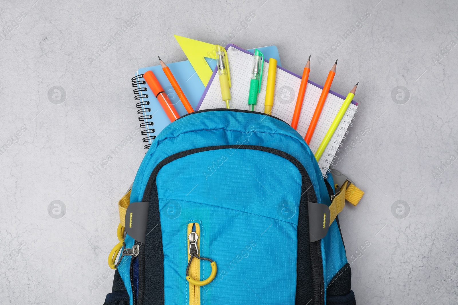 Photo of Flat lay composition with backpack and different school stationery on light grey table