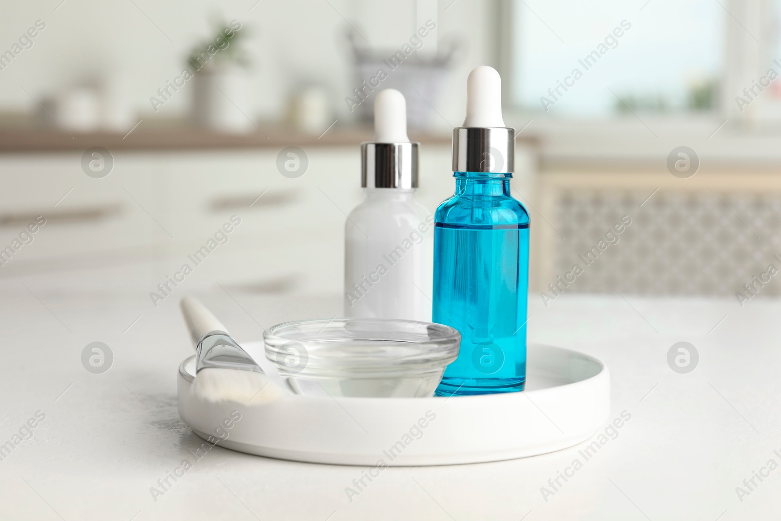 Photo of Peeling procedure. Bottles of chemical peel, bowl with liquid and brush on white table indoors