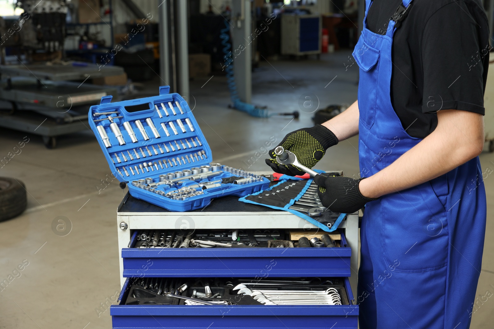 Photo of Auto mechanic with different tools at automobile repair shop, closeup