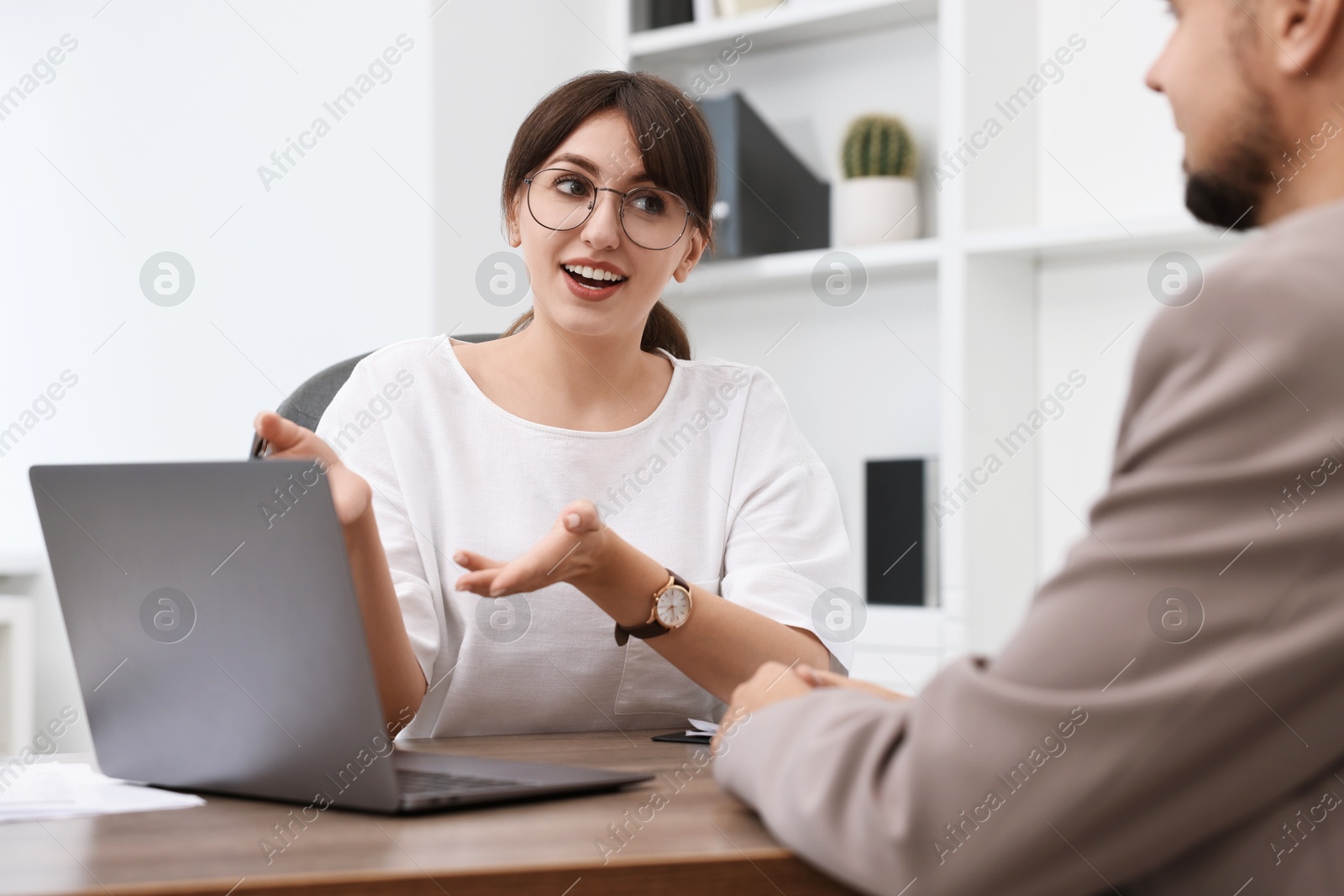 Photo of Consultant working with client at table in office. Business meeting