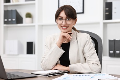 Portrait of smiling business consultant at table in office