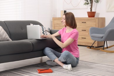 Teenager working with laptop at home. Remote job