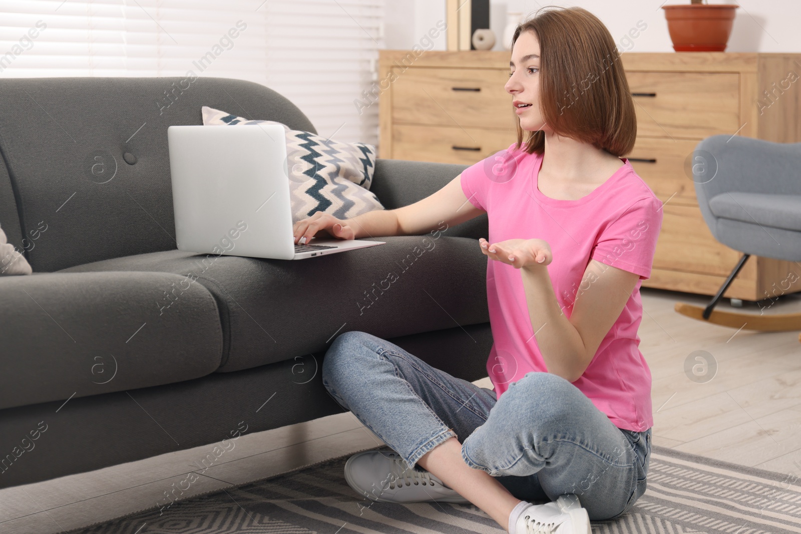 Photo of Teenager having video chat via laptop at home. Remote work