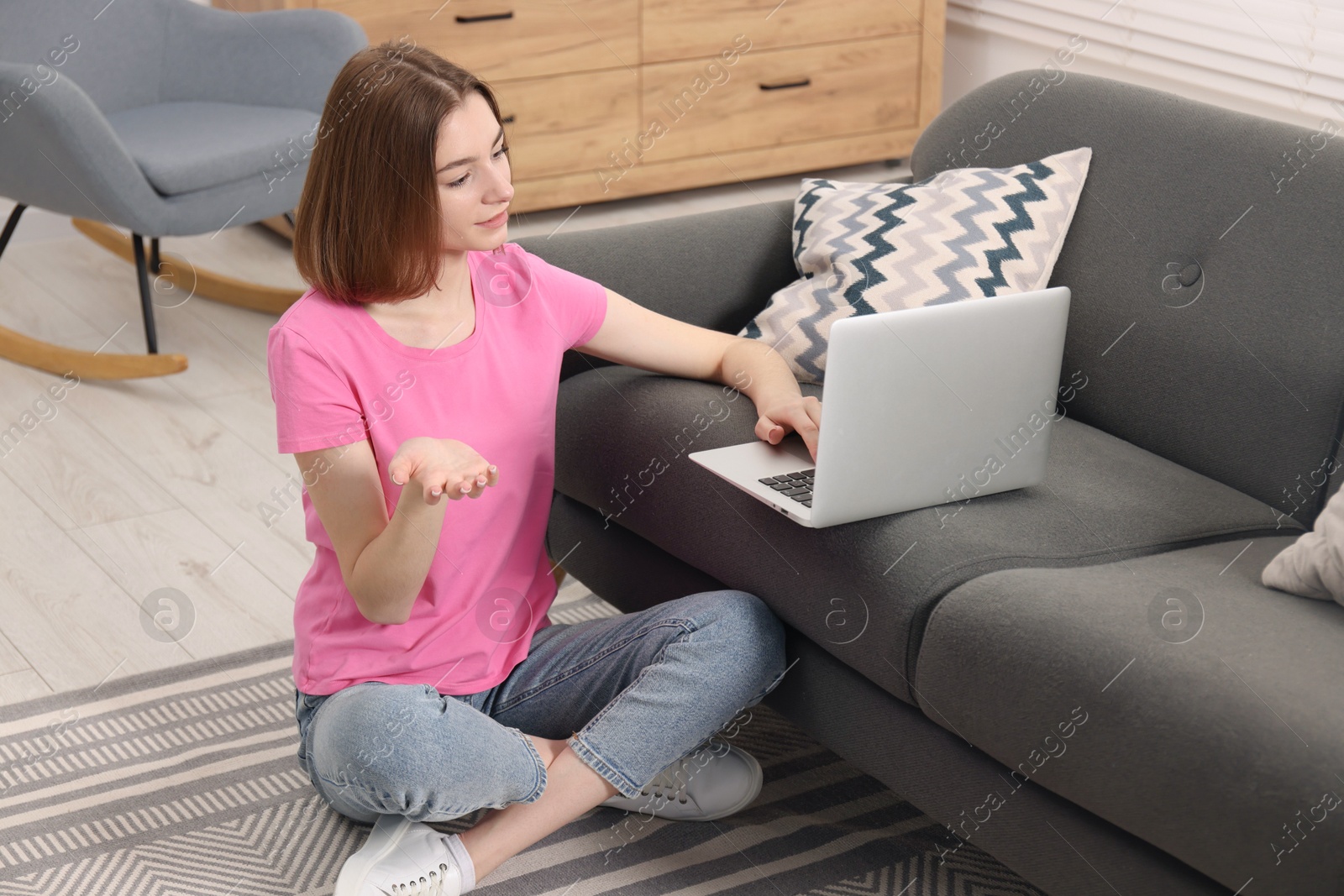 Photo of Teenager having video chat via laptop at home. Remote work