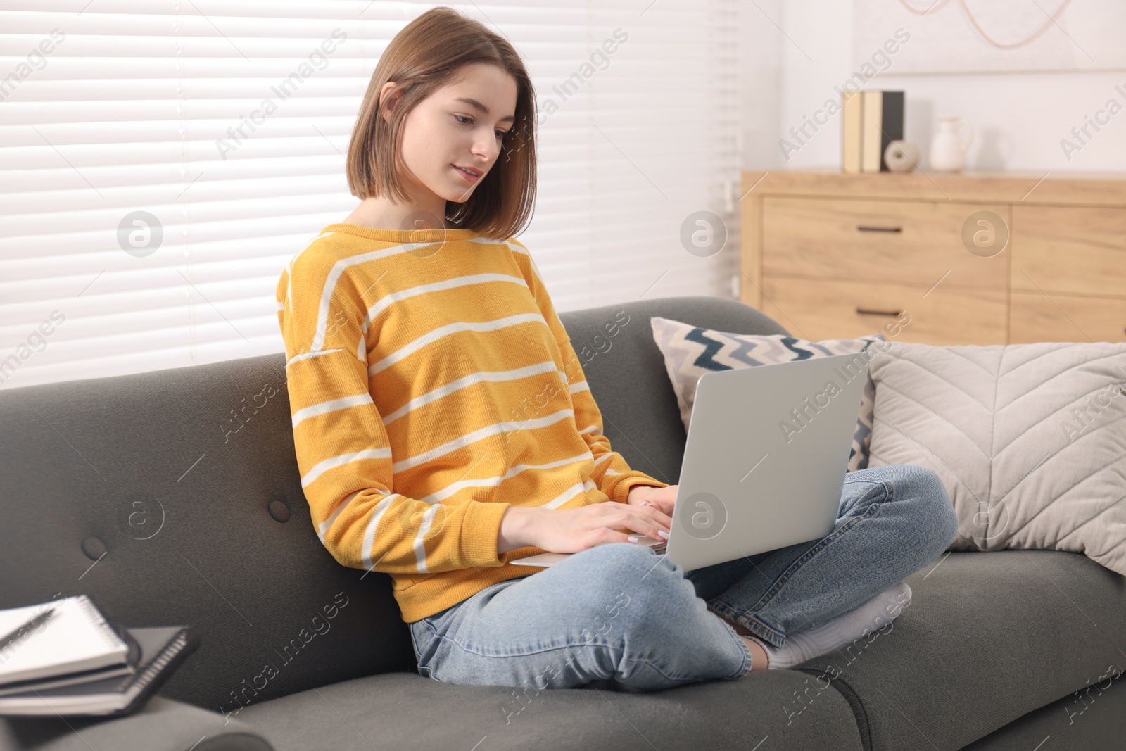 Photo of Teenager working with laptop at home. Remote job