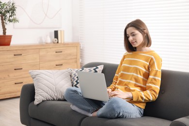 Teenager working with laptop at home. Remote job