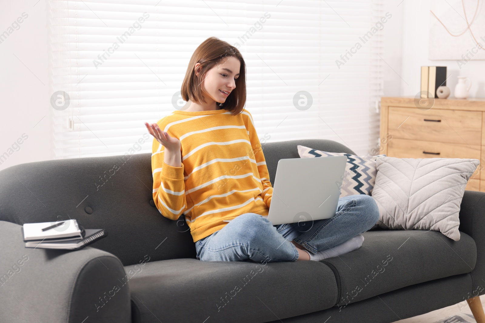 Photo of Teenager having video chat via laptop at home. Remote work