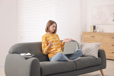 Photo of Teenager having video chat via laptop at home. Remote work