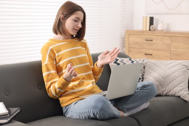 Photo of Teenager having video chat via laptop at home. Remote work