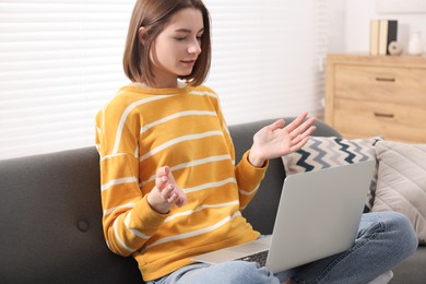 Photo of Teenager having video chat via laptop at home. Remote work