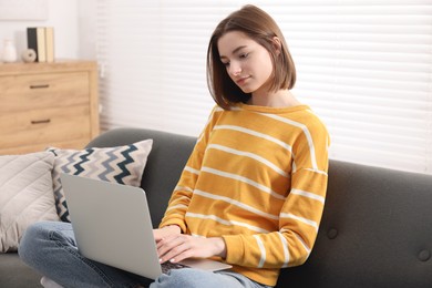 Teenager working with laptop at home. Remote job