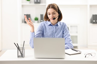 Teenager in headset having video chat via laptop at home. Remote work