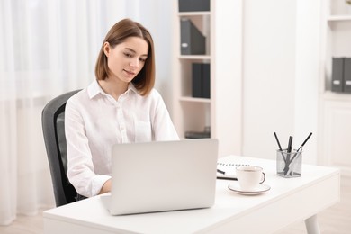 Teenager working with laptop at home. Remote job