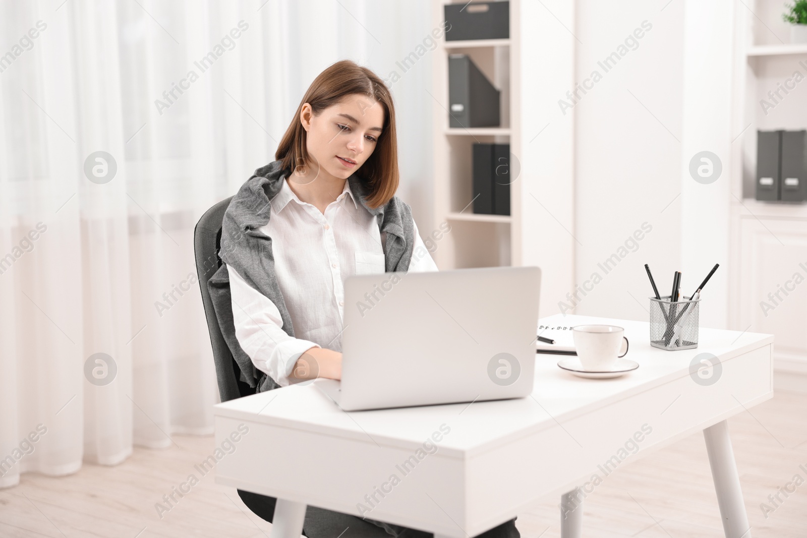 Photo of Teenager working with laptop at home. Remote job