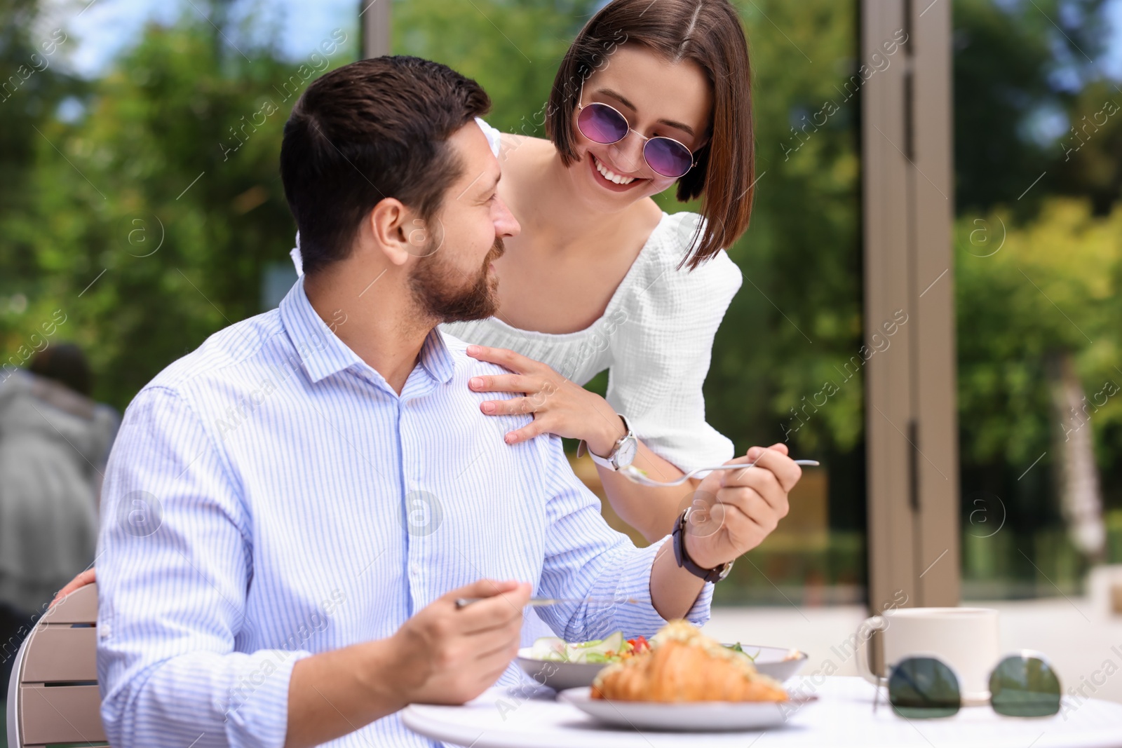 Photo of Happy couple having breakfast in outdoor cafe