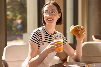 Happy woman having tasty breakfast in cafe