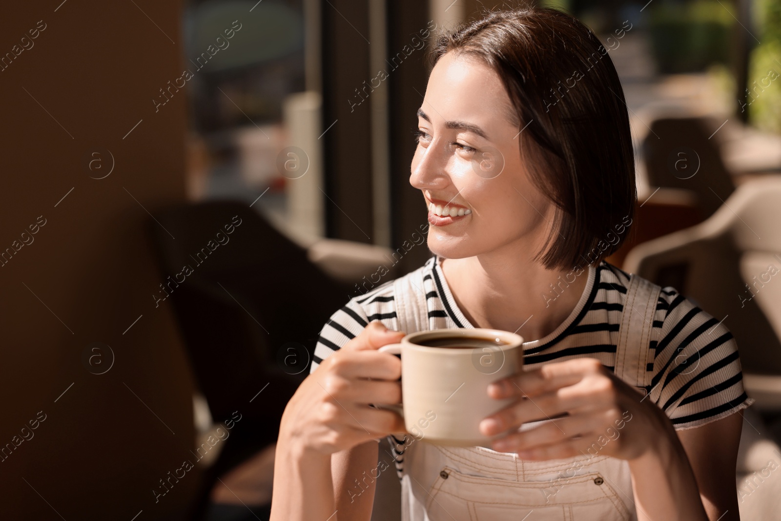 Photo of Happy woman having breakfast in cafe, space for text