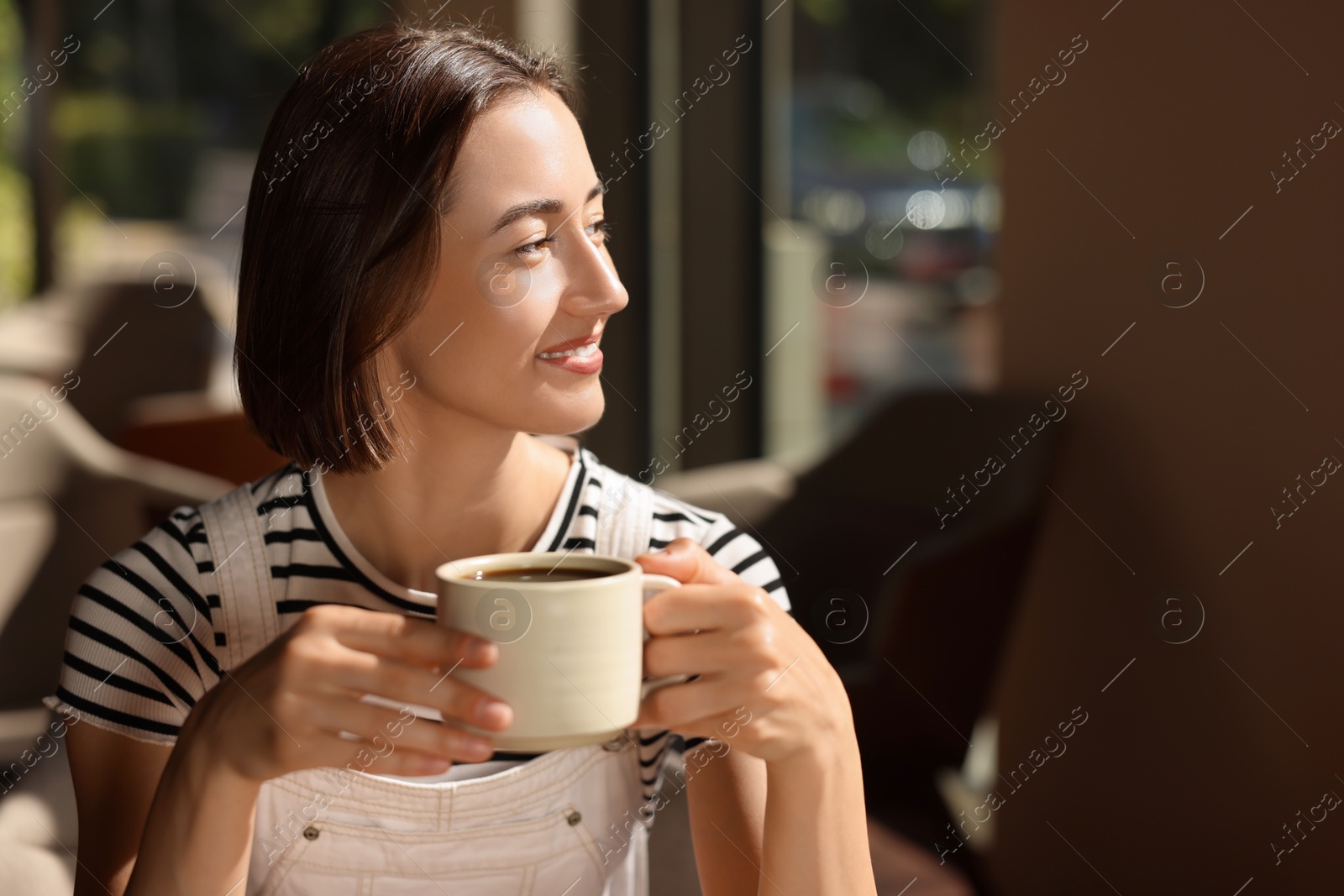 Photo of Happy woman having breakfast in cafe, space for text