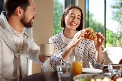 Photo of Happy couple having tasty breakfast in cafe