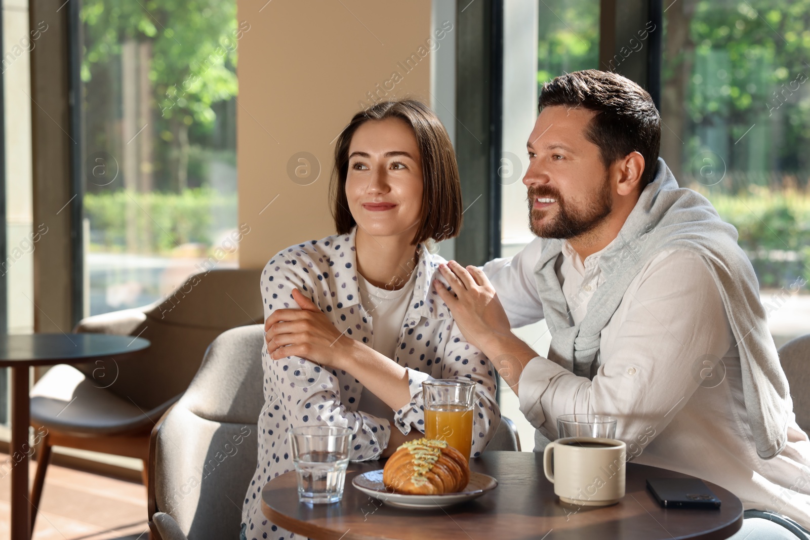 Photo of Happy couple having tasty breakfast in cafe