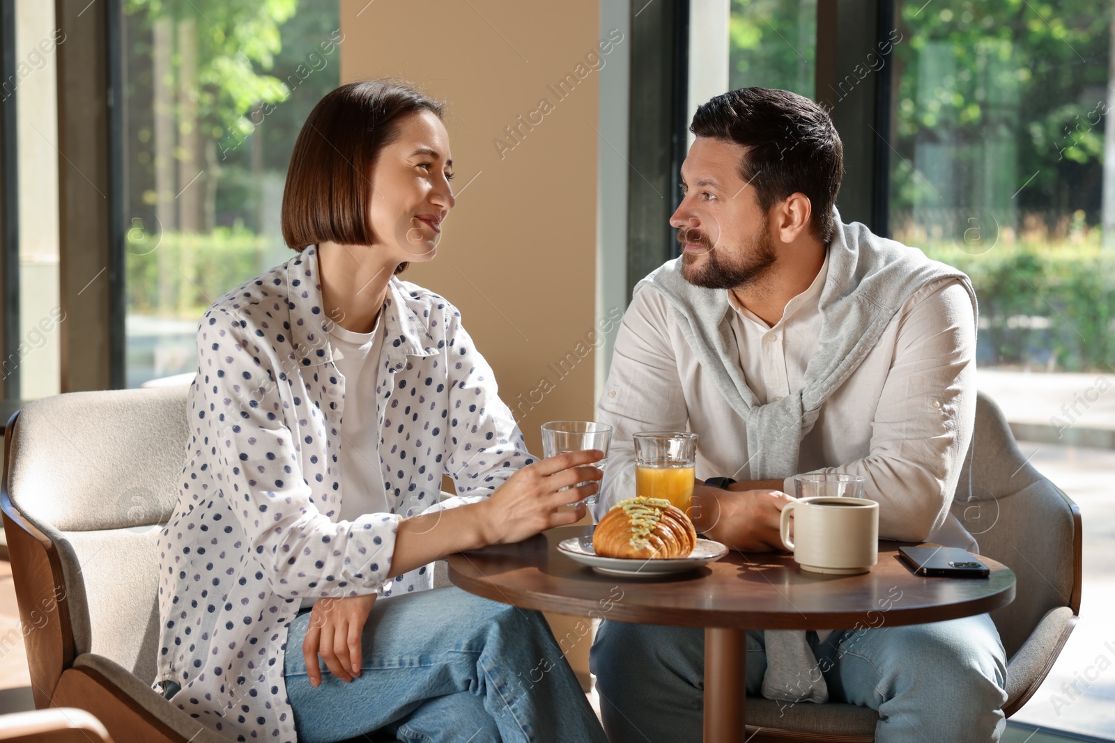 Photo of Happy couple having tasty breakfast in cafe