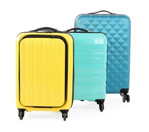 Photo of New yellow and light blue suitcases isolated on white