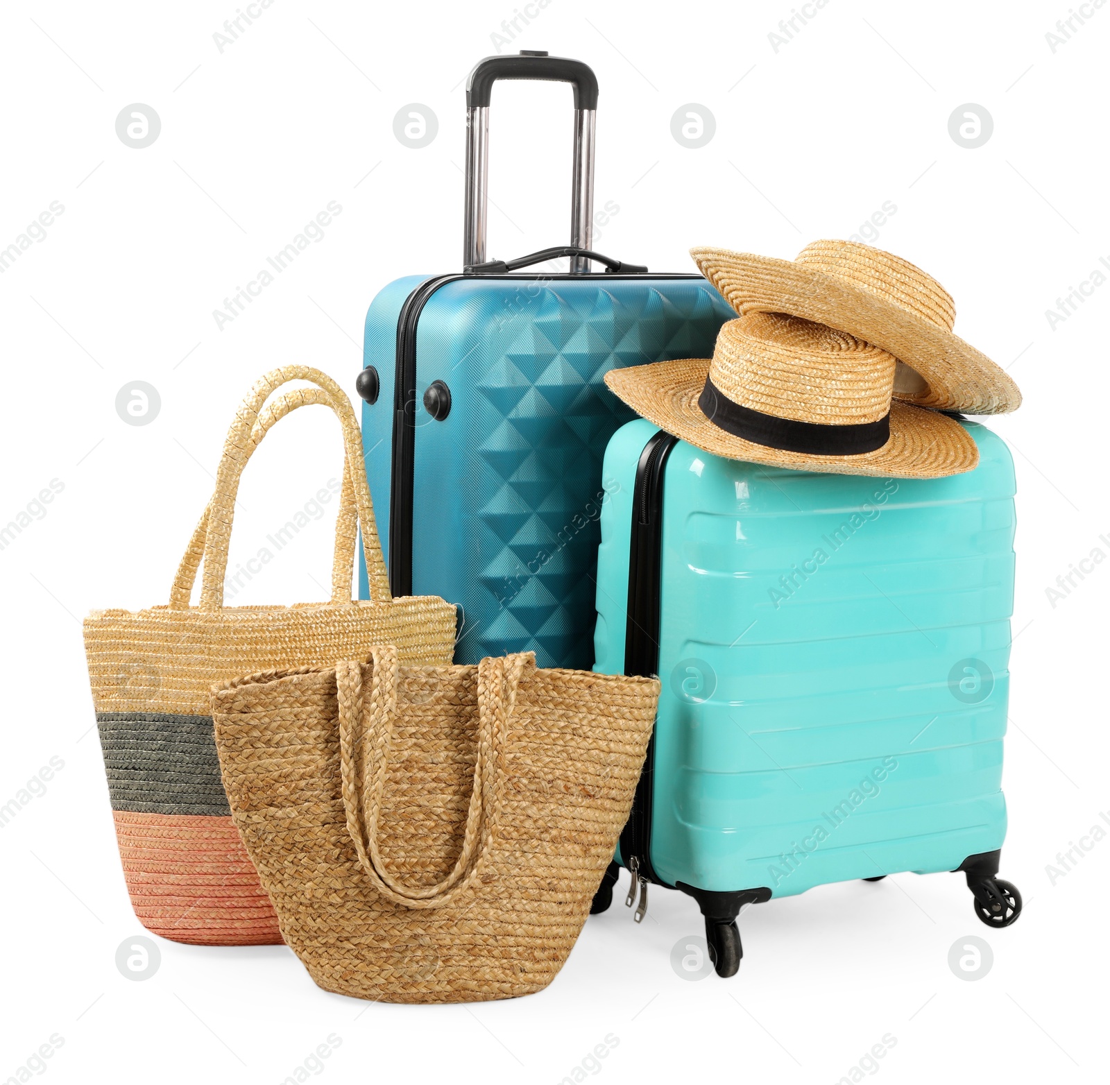 Photo of Light blue suitcases, bags and straw hats isolated on white