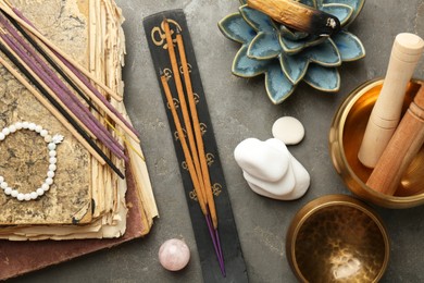 Flat lay composition with incense sticks on gray textured table. Om ligature