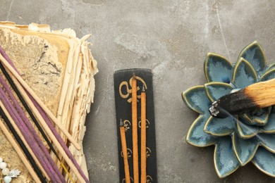 Photo of Flat lay composition with incense sticks on gray textured table. Om ligature