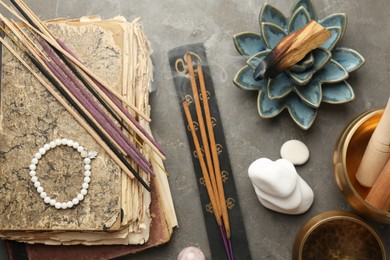 Photo of Flat lay composition with incense sticks on gray textured table. Om ligature