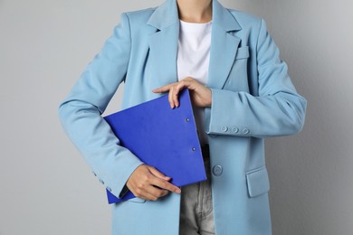 Photo of Engineer with clipboard on grey background, closeup