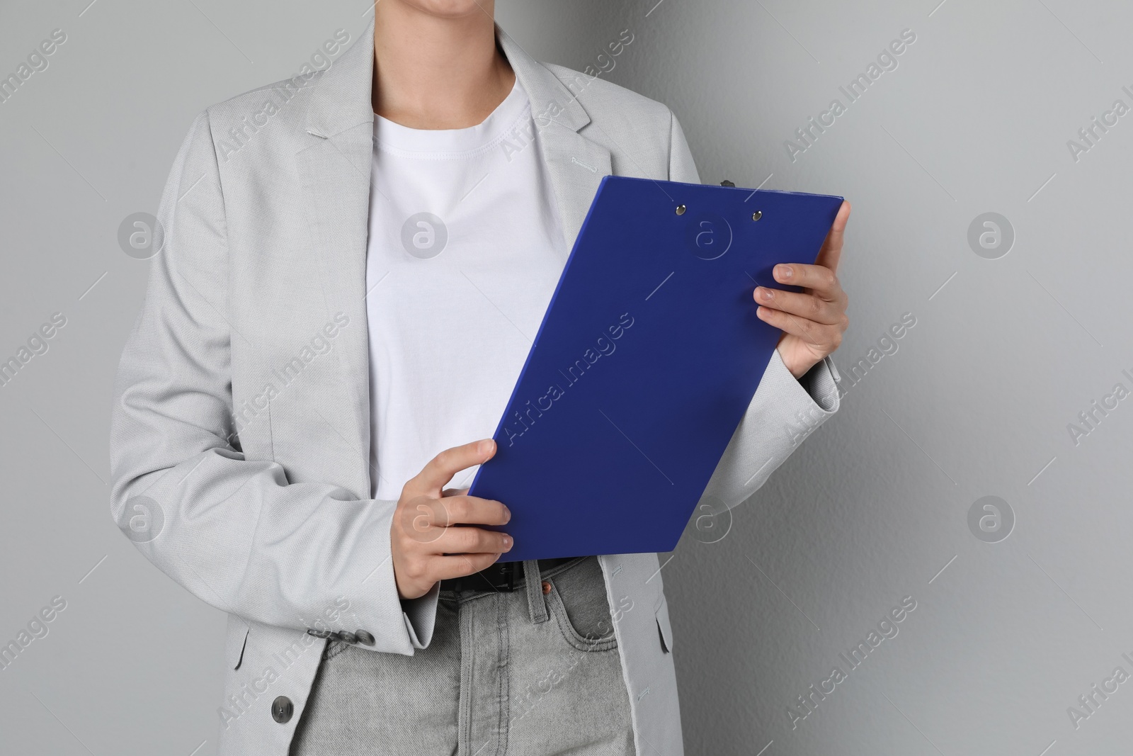 Photo of Engineer with clipboard on grey background, closeup