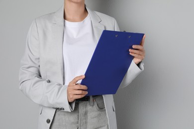 Photo of Engineer with clipboard on grey background, closeup